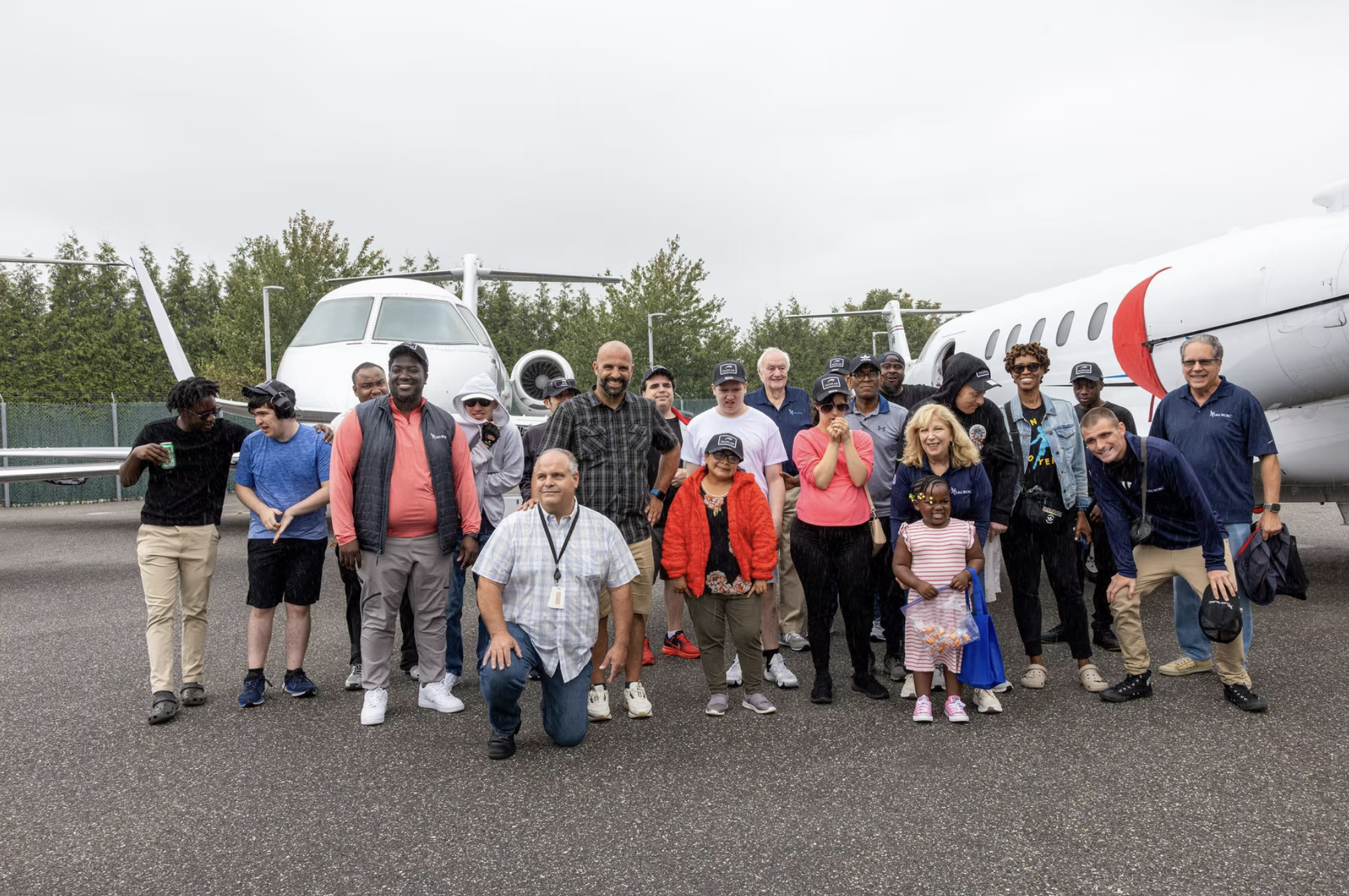 A group gathered in front of private aircraft